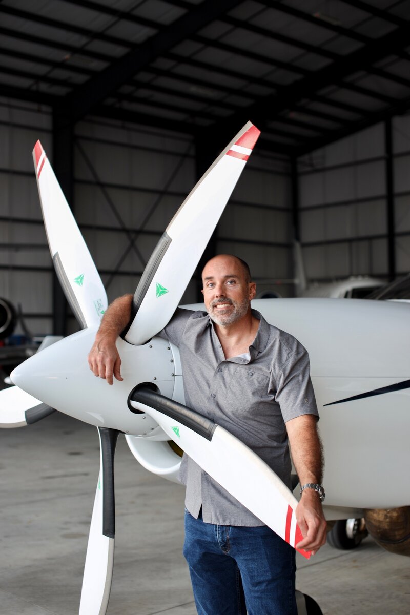Corey Rueth ATP-rated corporate pilot leaning on the 5-blade MT propeller of his Garrett-powered Lancair IV-P JetProp N331TP in Austin Texas